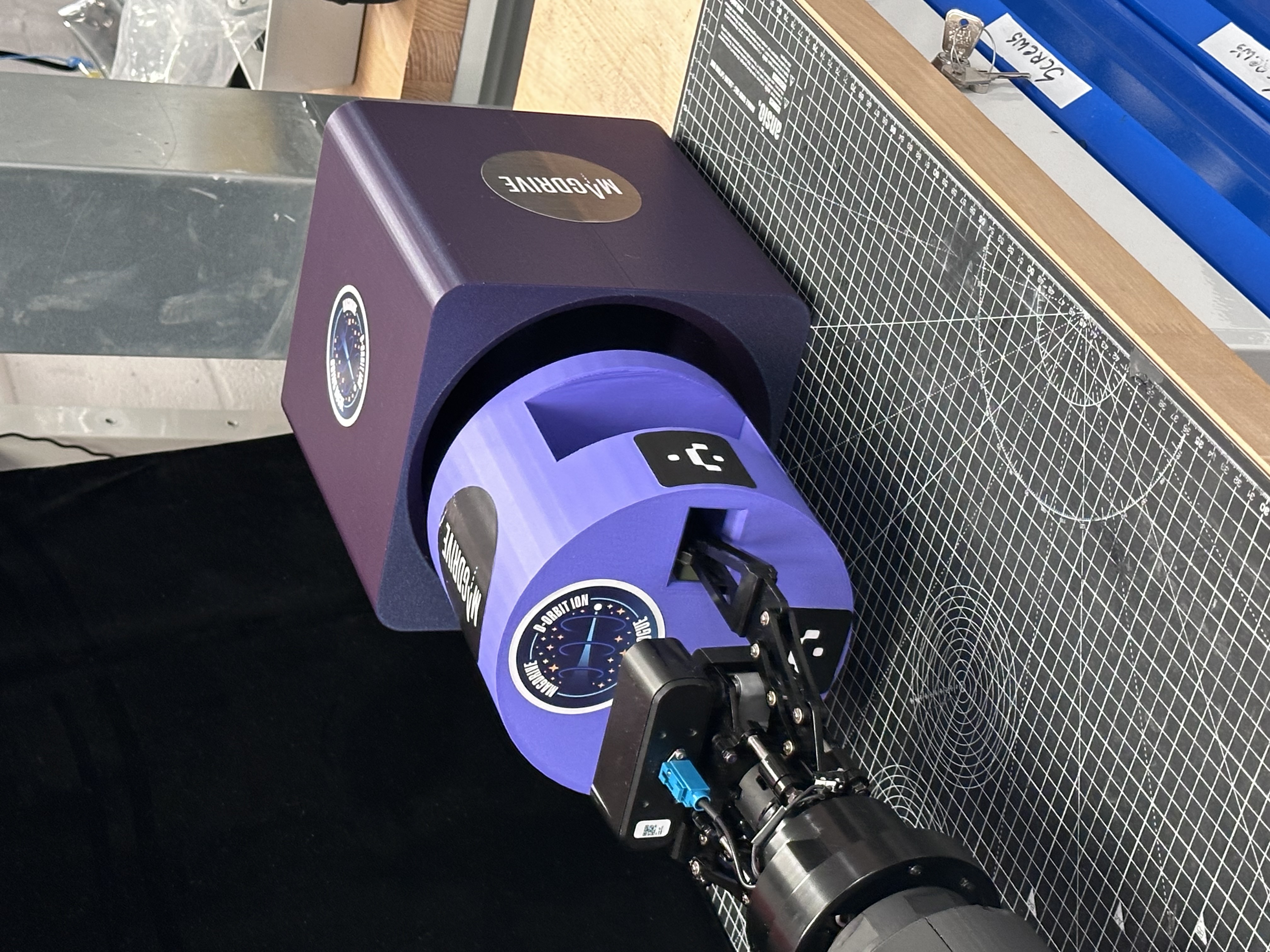 PLA cartridge and housing prototype engaged with Lodestar TARS gripper hardware on a benchtop.